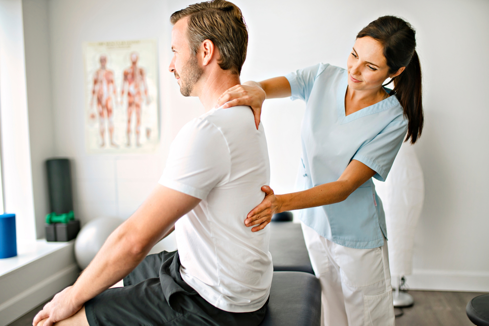Chiropractor performing Flexion/Distraction Therapy on a patient in a clinical setting, focusing on spinal health and pain relief.